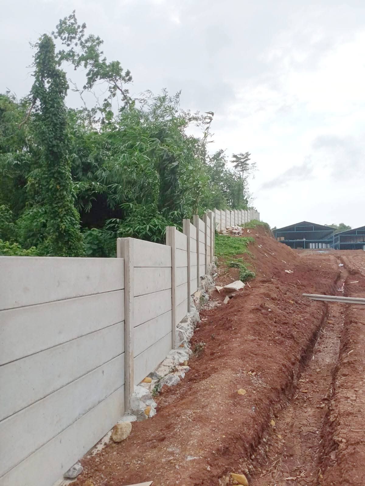 Proses pemasangan pagar panel beton yang rapi dan kokoh oleh tim ahli Artha Konstruksi di area perumahan.